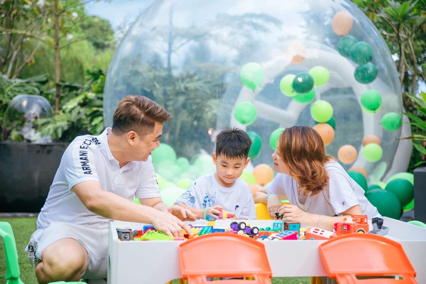 Family playing at a space sand table inside a bubble house