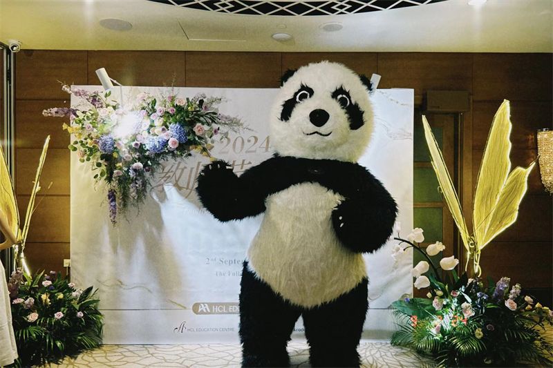 Panda mascot at a party with a floral backdrop