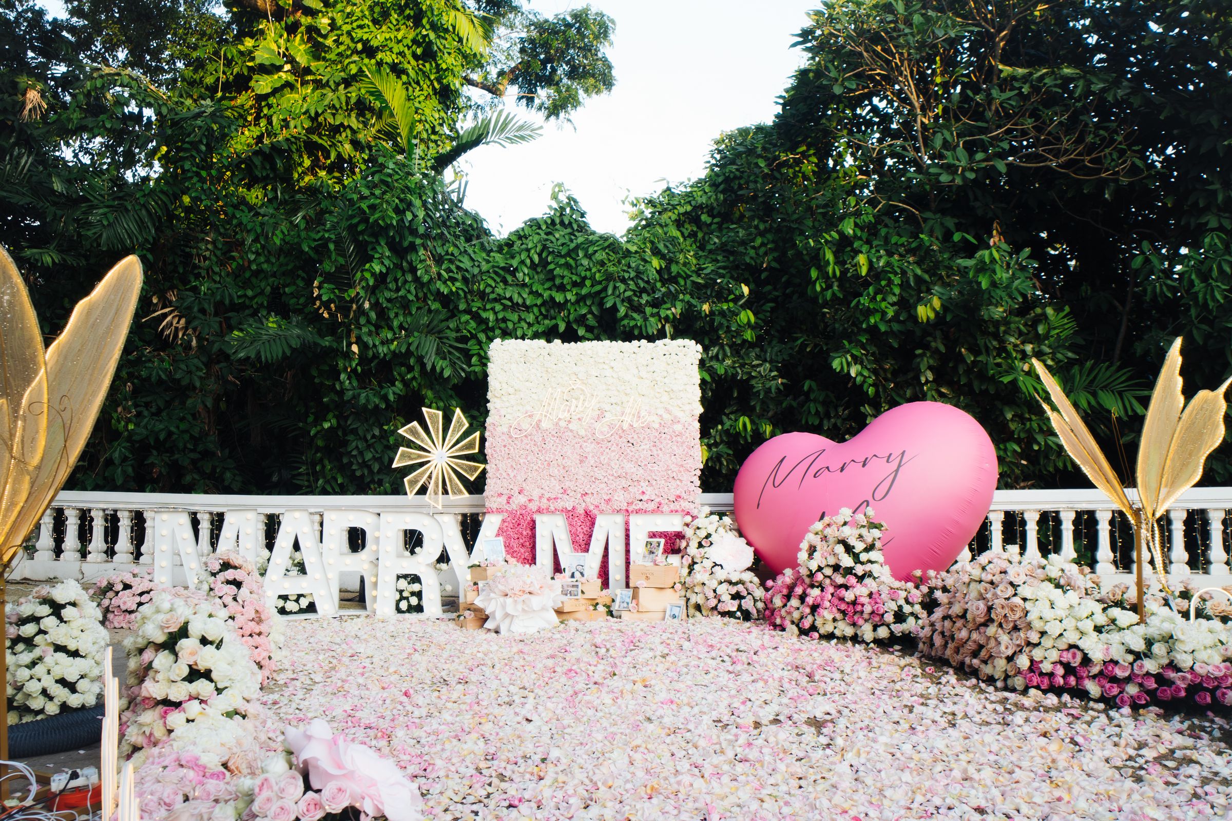Garden proposal setup with a pink heart and Marry Me letters