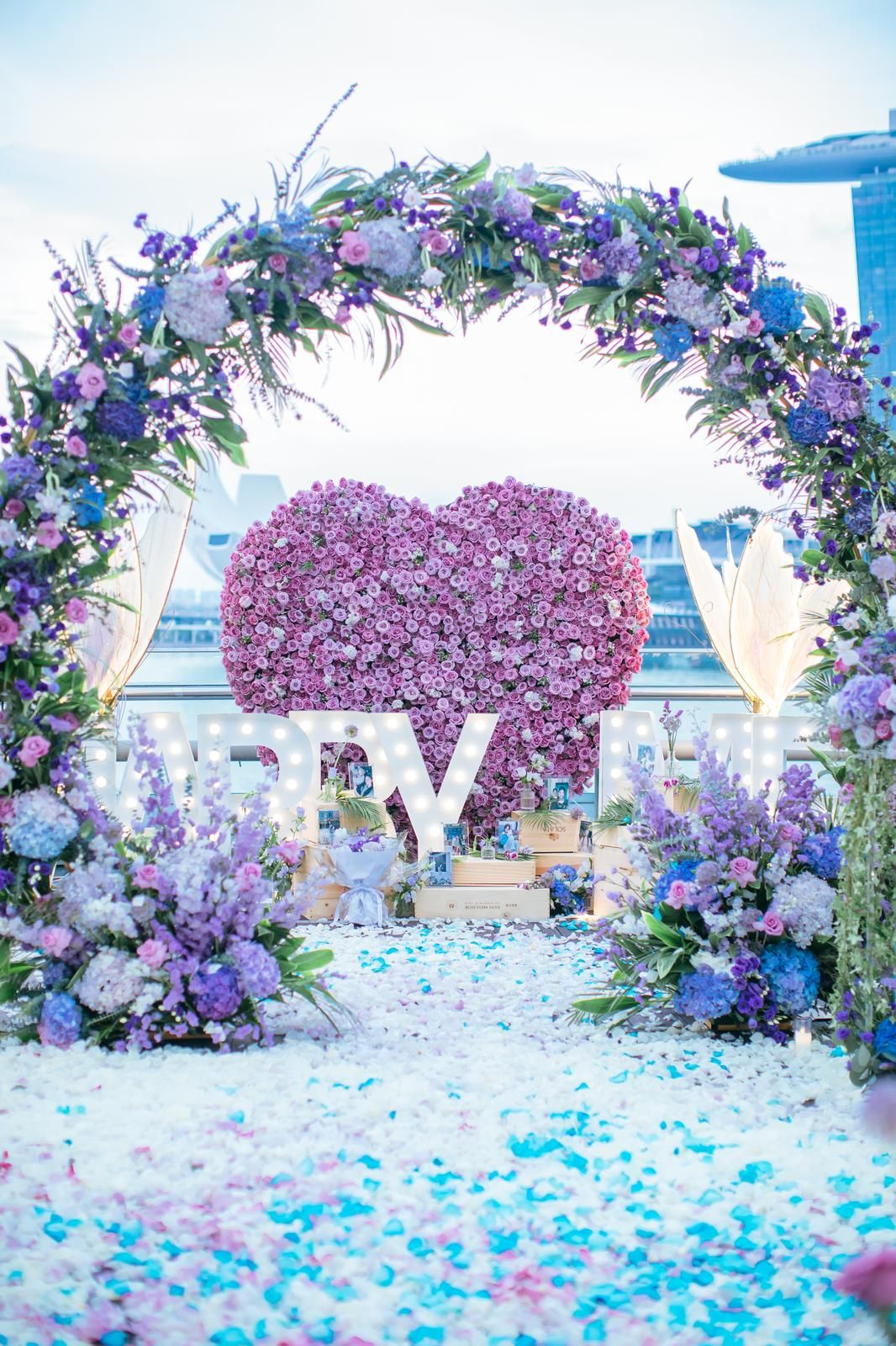 Purple floral heart arch with Marina Bay behind