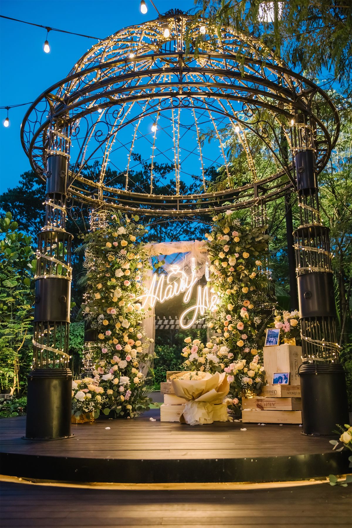Garden gazebo decorated with flowers and lights at night