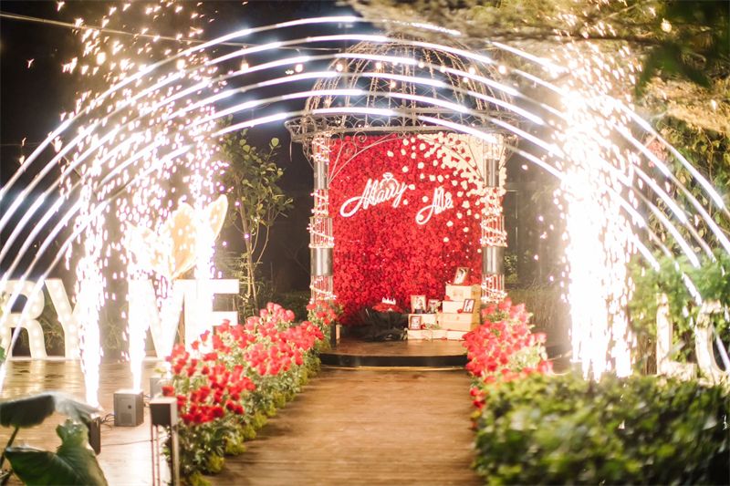 Sparkler tunnel leading to a red rose proposal setup