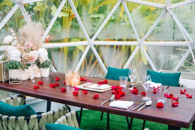 Dinner table with rose petals inside a dome
