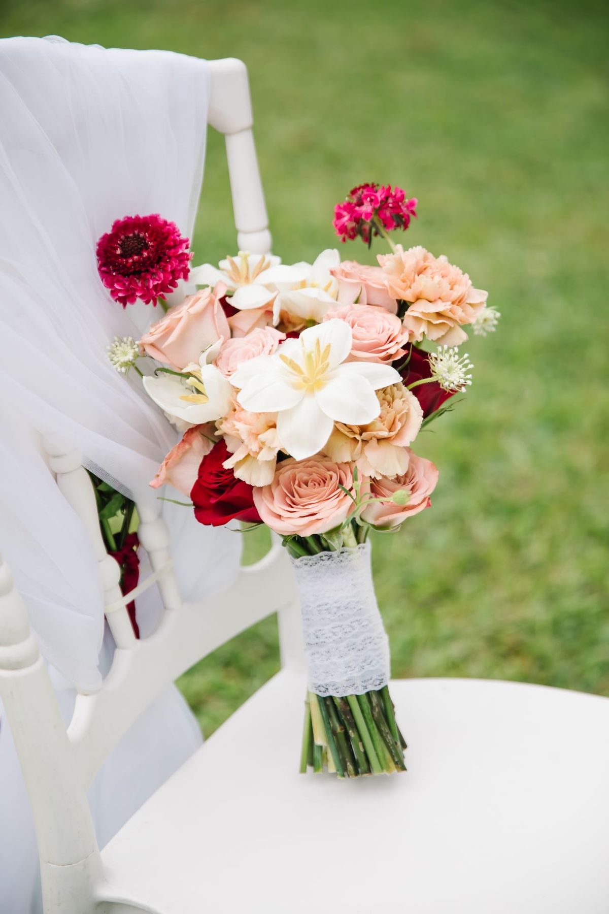 Pink and white bouquet tied to a ceremony chair